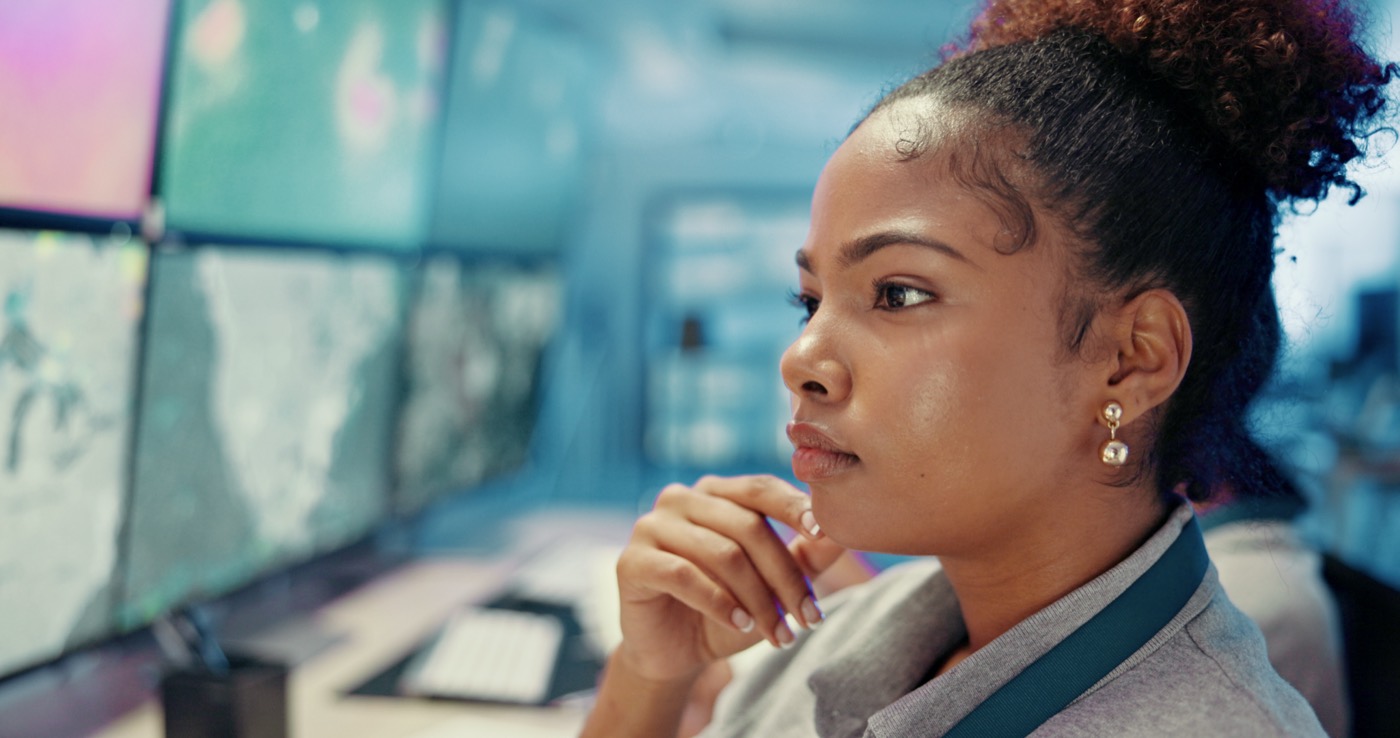 A woman thinking at a computer in an office