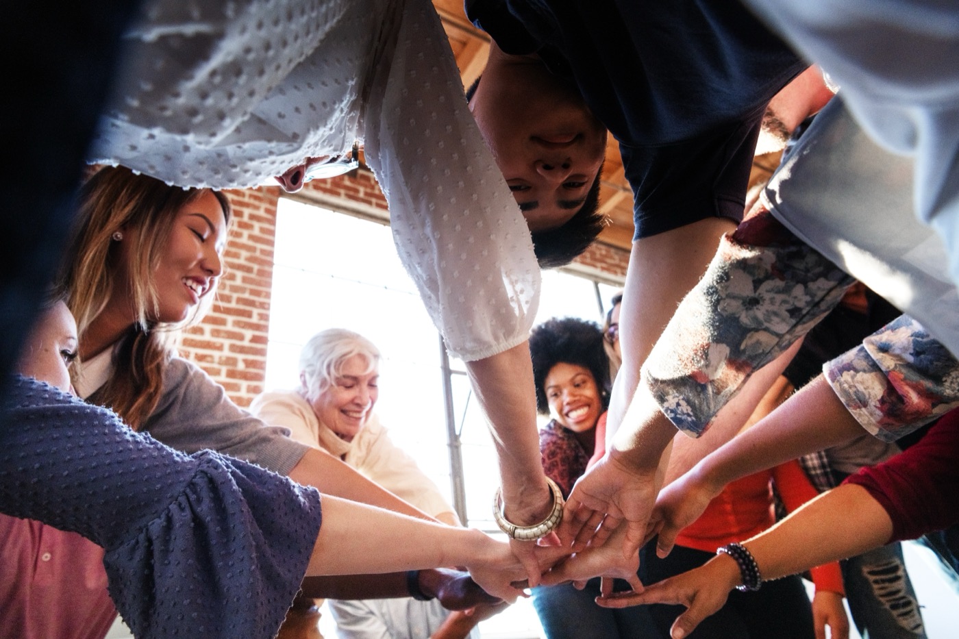A diverse group joining hands in a circle