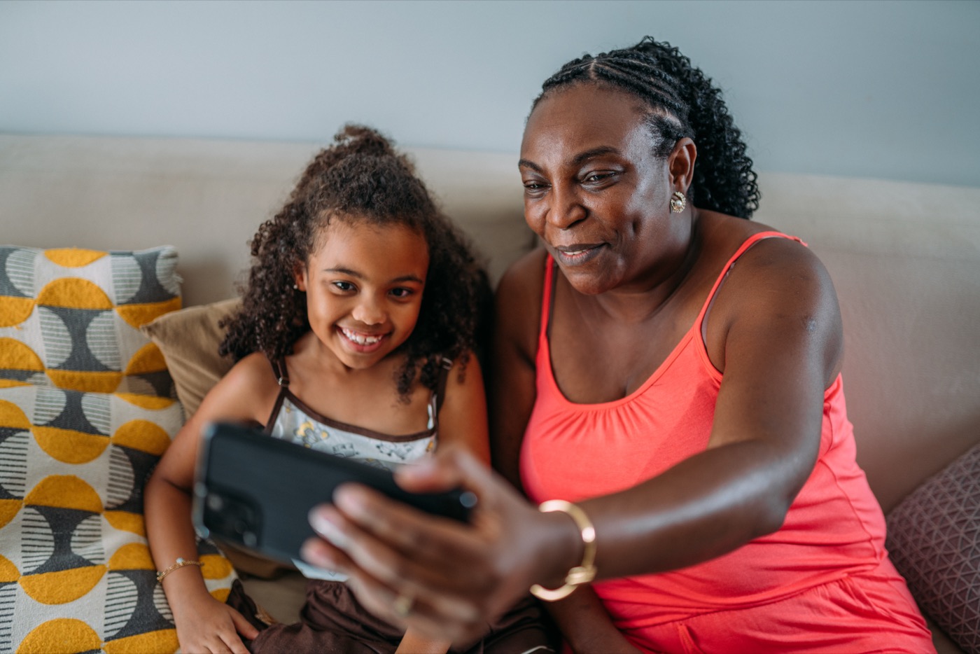 A grandmother and granddaughter recording a family story on a phone